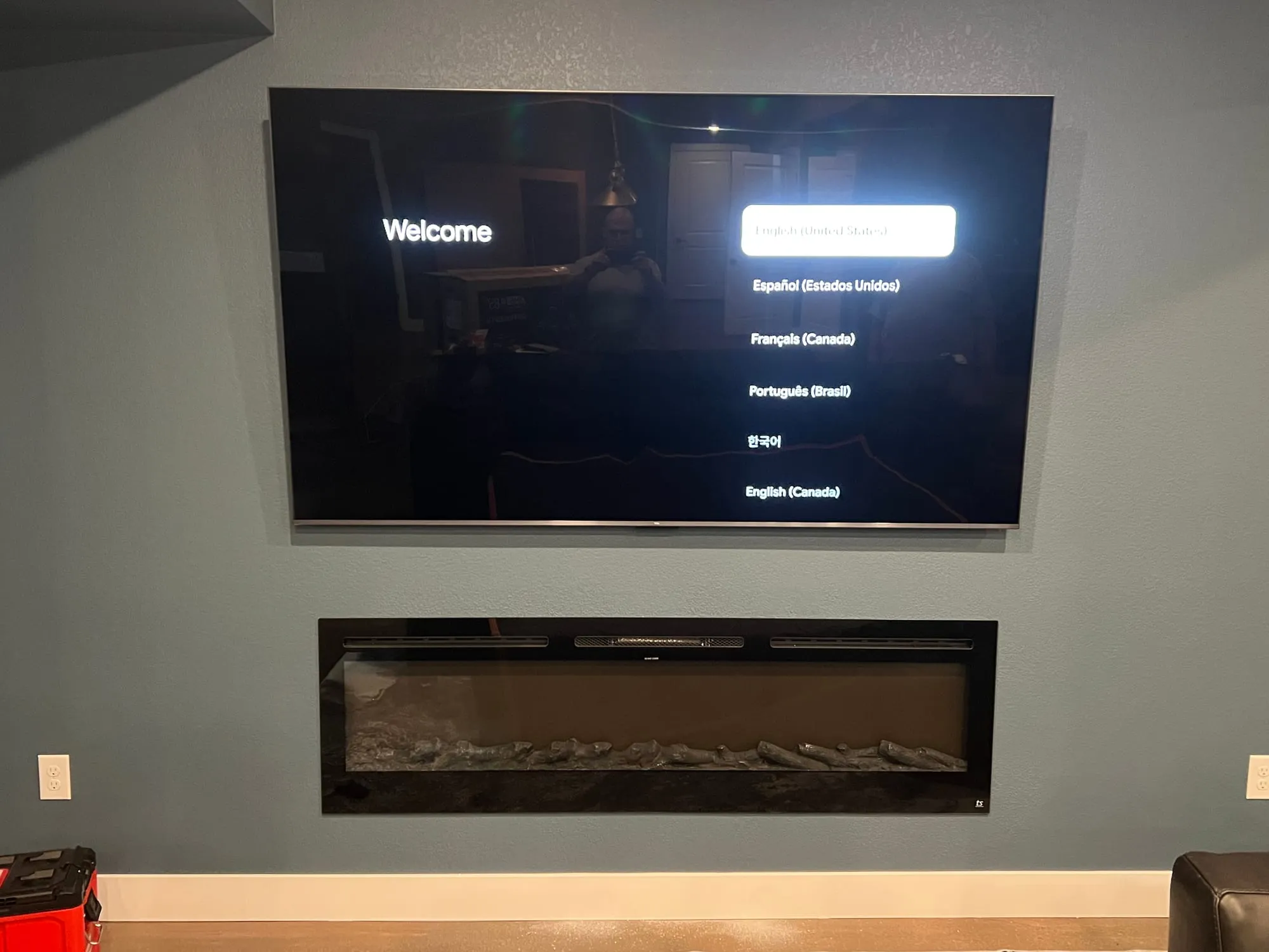 Large format TV mounted above a linear electric fireplace